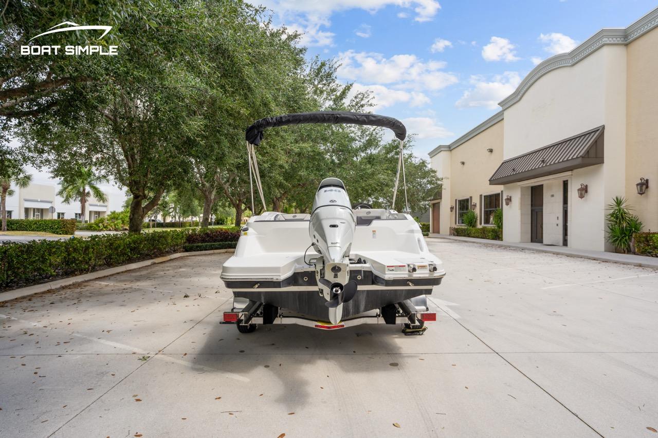 Slide: The Image of 2021 Hurricane SunDeck Sport 205 OB boat on trailer, parked in a sunny driveway. - 5