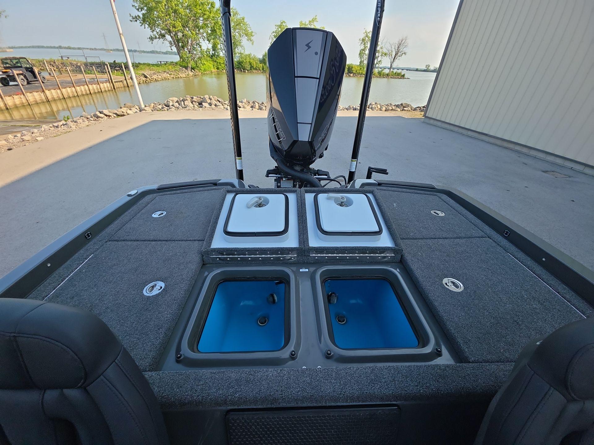 Slide: The Image of 2025 iKon LX21 boat with livewells, motor, and lake view in the background. - 18