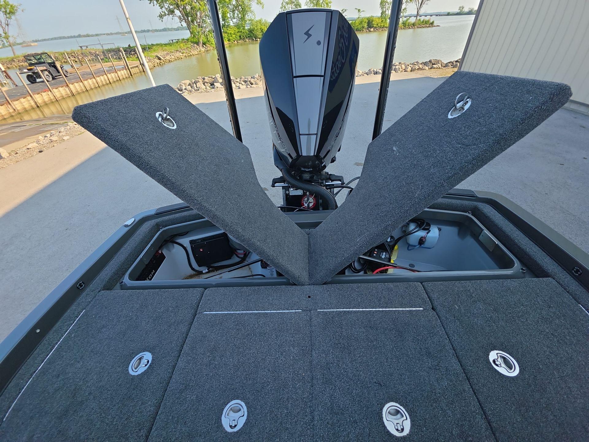 Slide: The Image of 2025 iKon LX21 boat with open storage compartments, near a waterfront. - 19