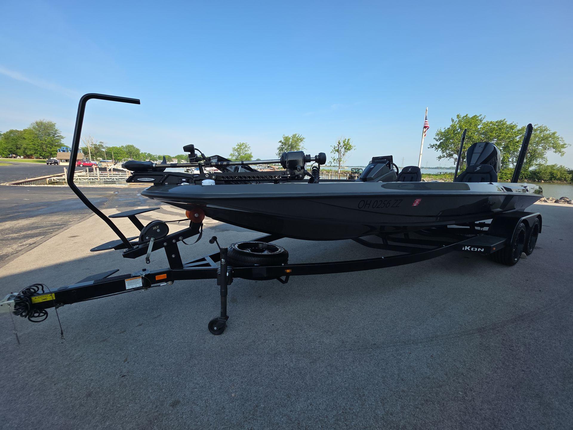 Slide: The Image of 2025 iKon LX21 boat on trailer at lakeside parking area. - 2