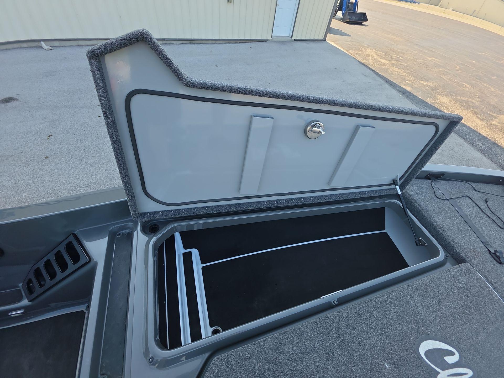 Slide: The Image of Open storage compartment on iKon LX21 boat, 2025 model, with carpeted interior. - 9
