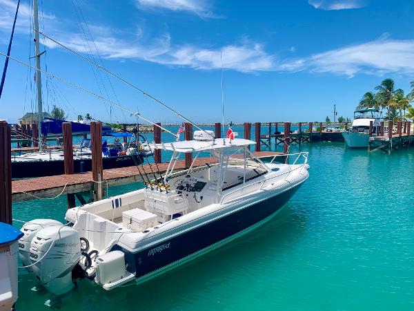 Slide: The Image of 2002 Intrepid 348 Walkaround boat docked in a sunny marina. - 0