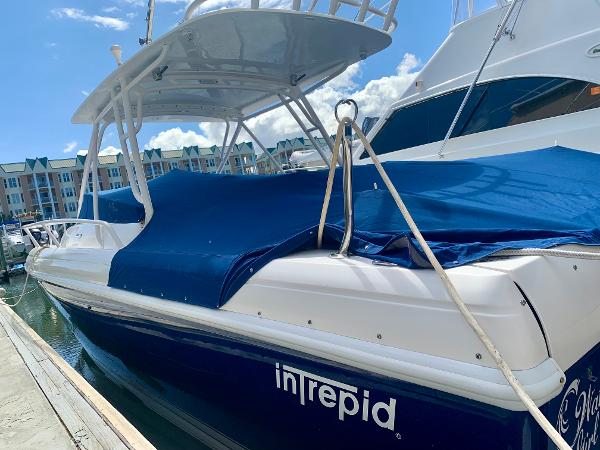Slide: The Image of 2002 Intrepid 348 Walkaround boat docked with blue cover. - 5