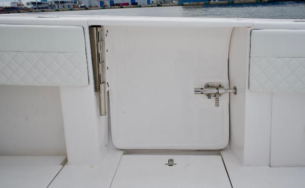Slide: The Image of 2023 Intrepid 475 Panacea boat interior with white cushioned seating and storage compartment. - 13