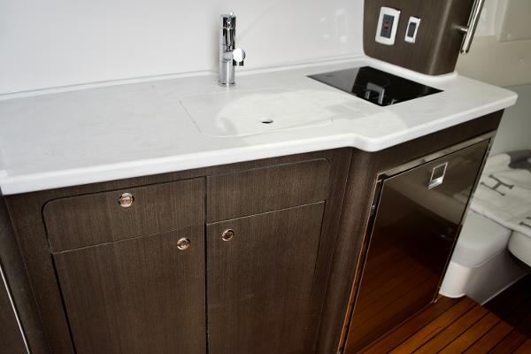 Slide: The Image of 2023 Intrepid 475 Panacea yacht kitchen with sink, stove, and storage cabinets. - 19
