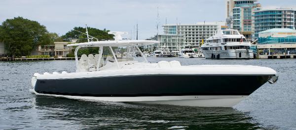 Slide: The Image of 2023 Intrepid 475 Panacea luxury boat cruising in a marina. - 2
