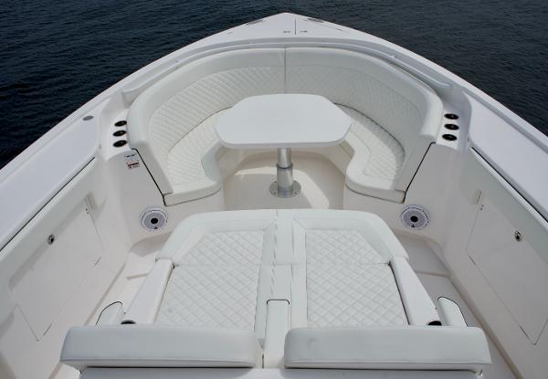 Slide: The Image of 2023 Intrepid 475 Panacea boat with white cushioned seating and table. - 5