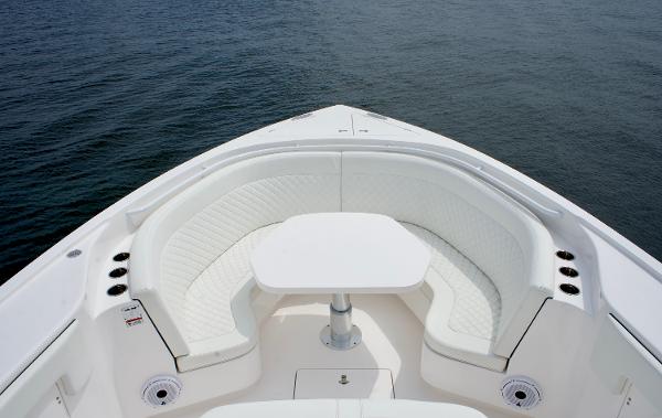 Slide: The Image of 2023 Intrepid 475 Panacea boat with white seating and table on the water. - 6