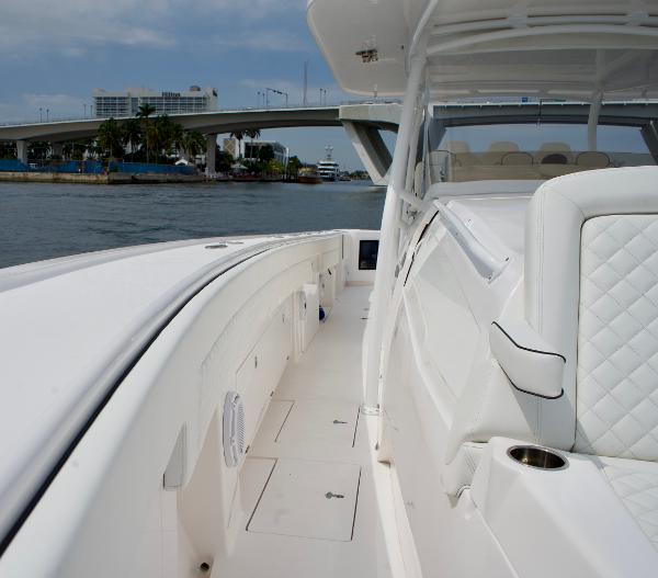 Slide: The Image of 2023 Intrepid 475 Panacea boat interior with white seating and coastal view. - 8