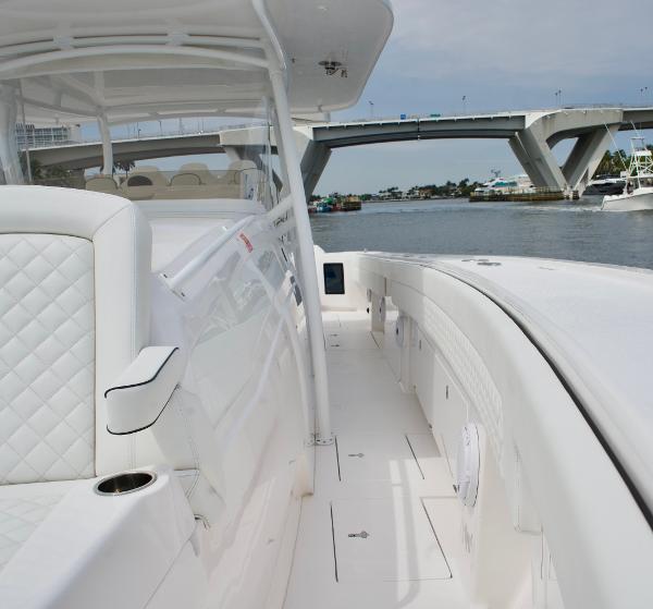 Slide: The Image of 2023 Intrepid 475 Panacea boat interior with white seating, docked near a bridge. - 9