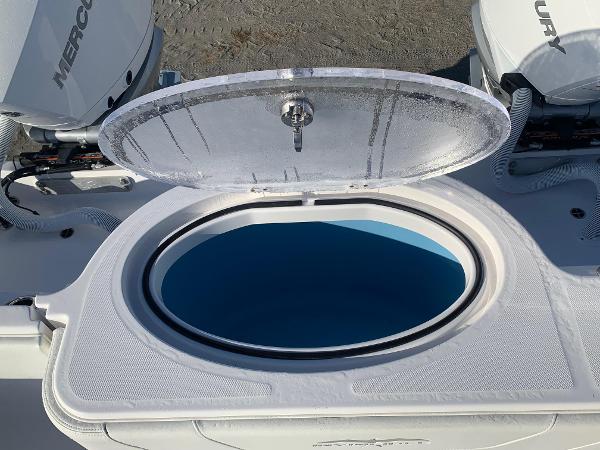 Slide: The Image of 2024 Invincible 33 Catamaran livewell with open lid and Mercury engines in background. - 12