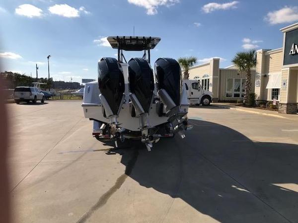 Slide: The Image of 2024 Invincible 36 boat with triple outboard engines in a parking lot. - 2