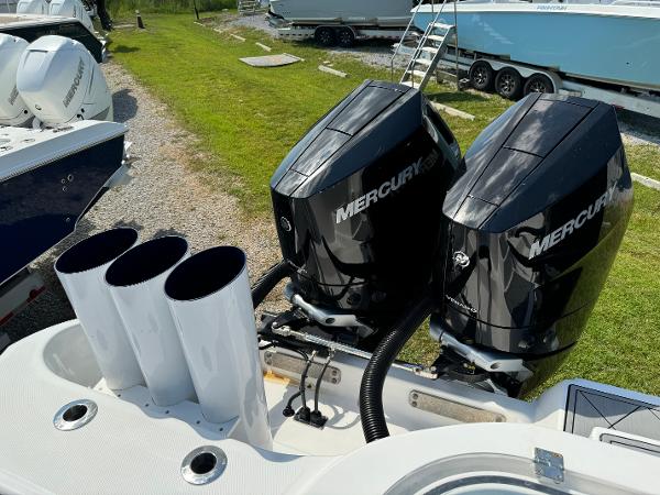 Slide: The Image of 2024 Invincible 40 Catamaran with dual Mercury outboard engines, docked on grass. - 26