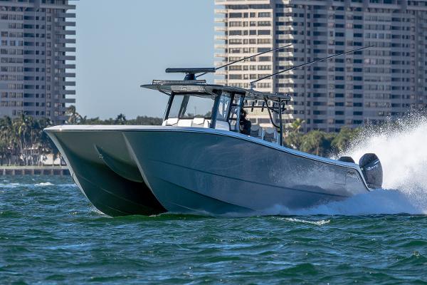 Slide: The Image of 2026 Invincible 46 Catamaran cruising on water with cityscape background. - 1