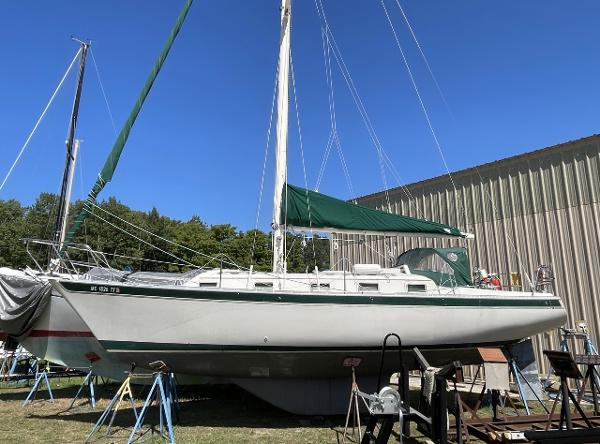 Slide: The Image of 1983 Irwin Citation 34 sailboat on stands, green sail cover, outdoor storage. - 1