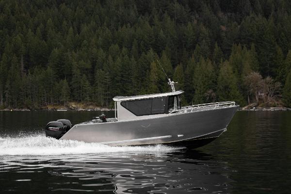 Slide: The Image of 2025 Jasper Marine Defender 22 boat cruising on a lake with forested background. - 17