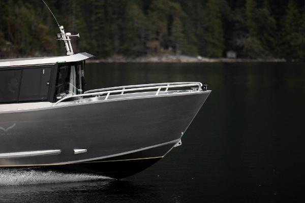 Slide: The Image of 2025 Jasper Marine Defender 22 boat cruising on a calm lake with forested background. - 19