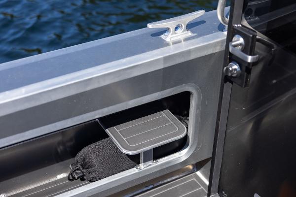 Slide: The Image of Jasper Marine Defender 22 (2025) boat interior detail with storage compartment and water view. - 29