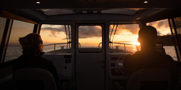 Slide: The Image of 2025 Jasper Marine Defender 22 boat at sunset, interior view with two people. - 34