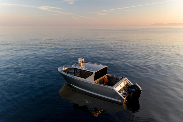Slide: The Image of 2025 Jasper Marine Defender 22 boat on calm water at sunset. - 35
