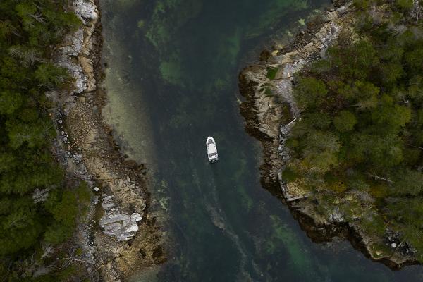 Slide: The Image of Aerial view of Jasper Marine Defender 22 boat navigating between rocky shores, 2025 model. - 36