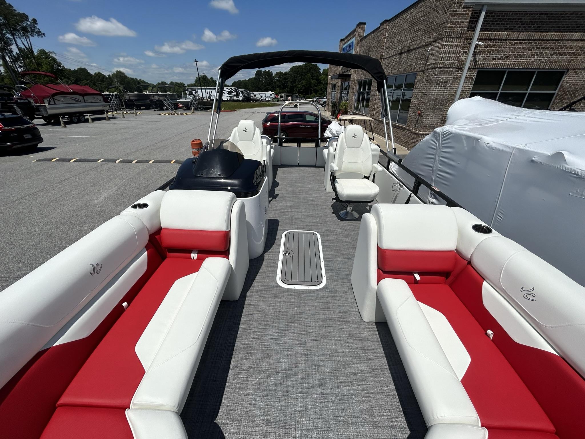 Slide: The Image of 2024 JC 247 TT pontoon boat with red and white seating, docked outdoors. - 11