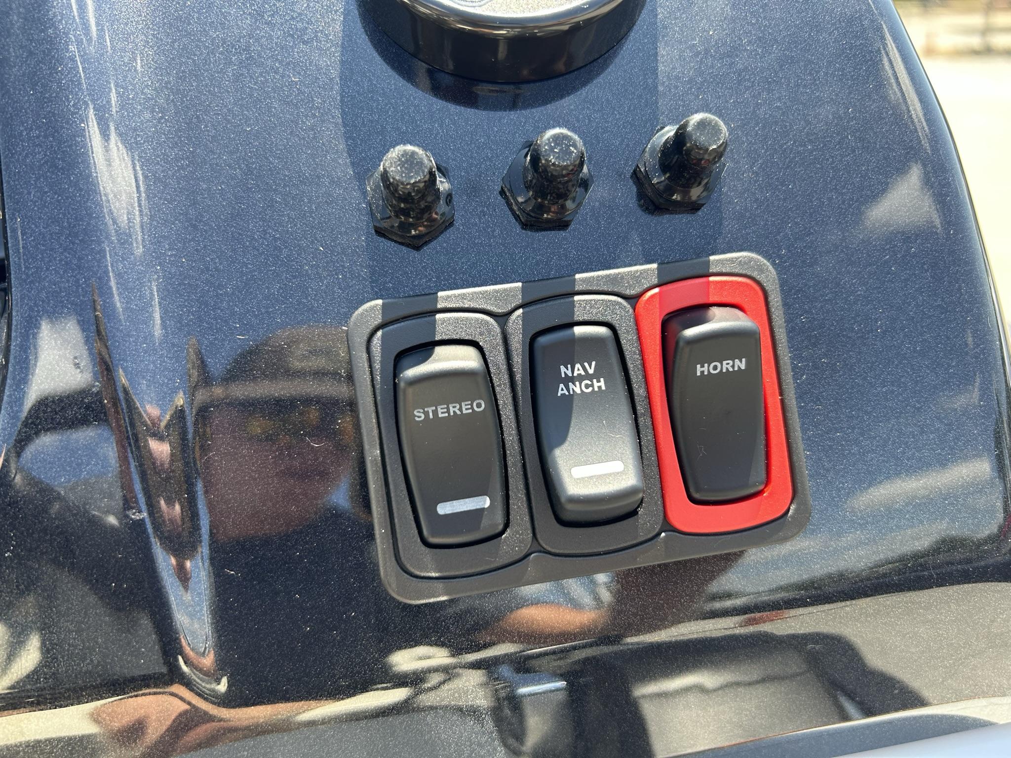 Slide: The Image of Control panel of 2024 JC 247 TT boat with stereo, navigation, and horn switches. - 19