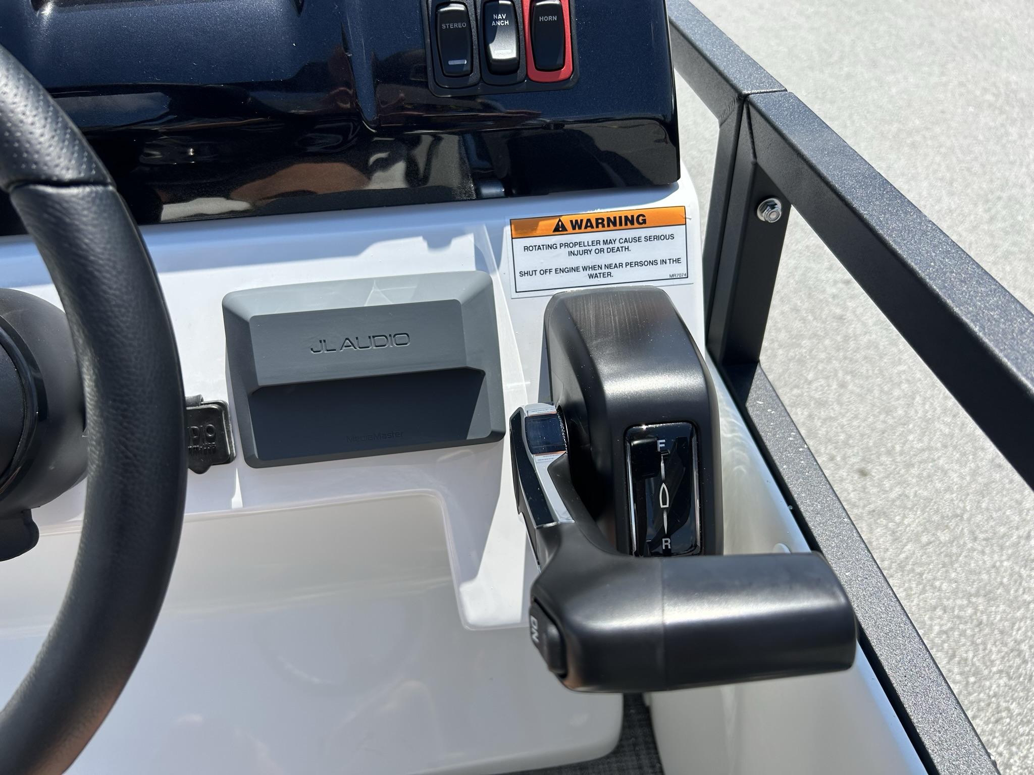 Slide: The Image of 2024 JC 247 TT boat controls with JL Audio system and warning label. - 4