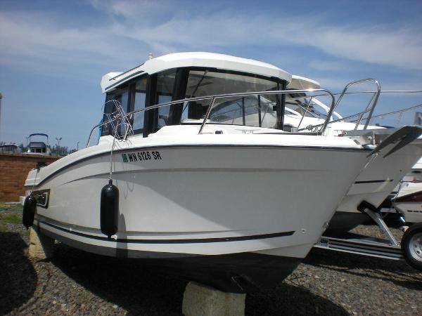 Slide: The Image of 2019 Jeanneau 695 boat on display, white exterior, docked on land. - 15