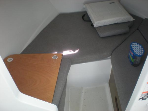 Slide: The Image of 2019 Jeanneau 695 cabin interior with gray cushions and wooden table. - 3
