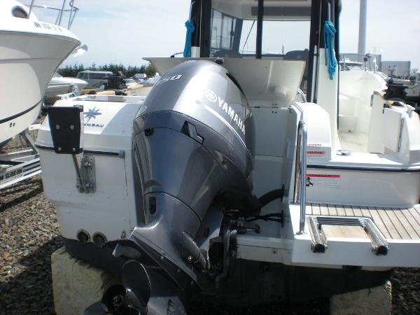 Slide: The Image of 2019 Jeanneau 695 boat with Yamaha outboard motor, docked outdoors. - 4