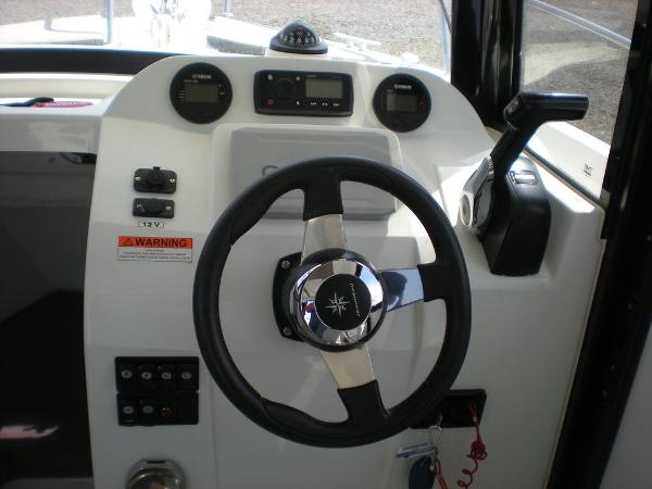Slide: The Image of 2019 Jeanneau 695 helm with steering wheel and control panel. - 5