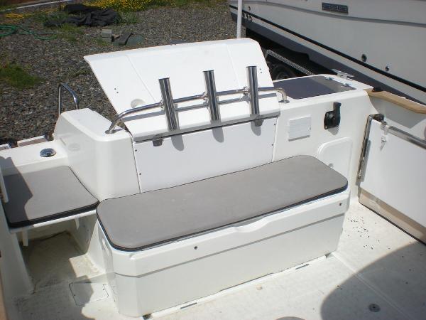 Slide: The Image of 2019 Jeanneau 695 boat seating area with rod holders and storage. - 9