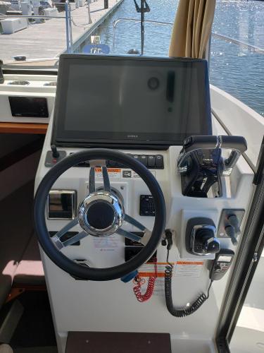 Slide: The Image of Helm station of 2016 Jeanneau Merry Fisher 855 boat with steering wheel and navigation equipment. - 12