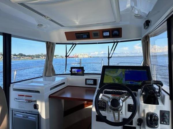Slide: The Image of Interior helm of 2016 Jeanneau Merry Fisher 855 with navigation equipment and waterfront view. - 13