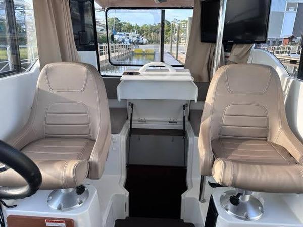 Slide: The Image of 2016 Jeanneau Merry Fisher 855 interior cockpit with dual seats and helm station. - 7
