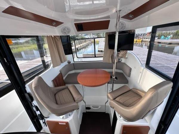 Slide: The Image of 2016 Jeanneau Merry Fisher 855 interior with seating and round table. - 9