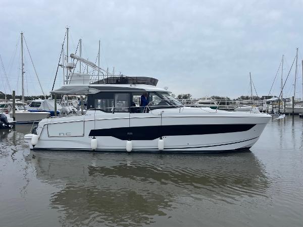 Slide: The Image of 2024 Jeanneau NC 1295 FLY yacht docked in a marina. - 26