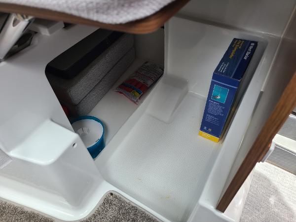 Slide: The Image of Storage compartment in a 2021 Jeanneau NC 795 S2 boat with various items. - 9
