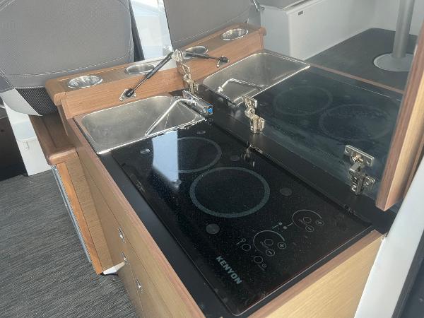 Slide: The Image of 2020 Jeanneau NC 895 kitchen with dual sinks and Kenyon electric cooktop. - 11