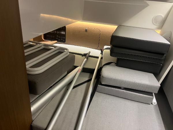 Slide: The Image of 2020 Jeanneau NC 895 interior storage with cushions and metal frames. - 13
