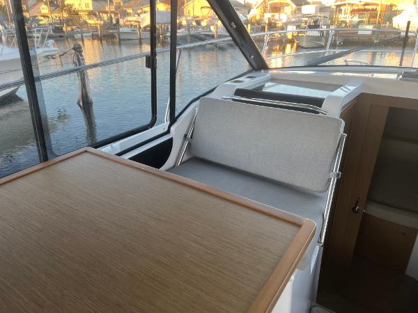 Slide: The Image of Interior of 2020 Jeanneau NC 895 boat with wooden table and seating. - 8