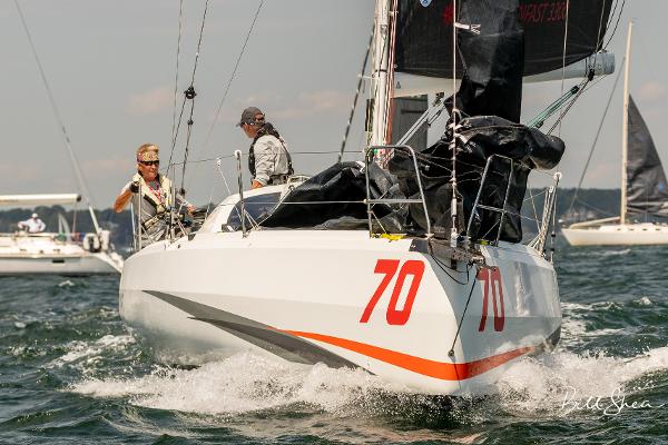 Slide: The Image of 2023 Jeanneau Sun Fast 3300 sailboat racing on open water, number 70 visible. - 8