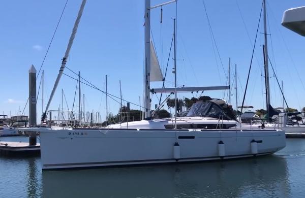 Slide: The Image of 2020 Jeanneau Sun Odyssey 389 sailboat docked in a marina under clear blue skies. - 1