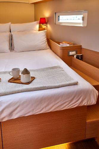 Slide: The Image of Cozy cabin interior of 2026 Jeanneau Sun Odyssey 410 with modern bedding and warm lighting. - 11