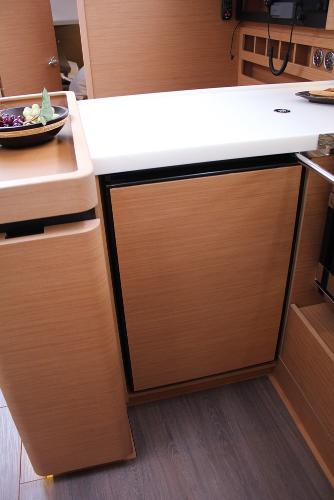 Slide: The Image of 2024 Jeanneau Sun Odyssey 440 galley with modern wood cabinetry and sleek countertop. - 18