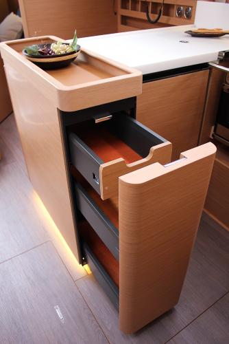 Slide: The Image of 2024 Jeanneau Sun Odyssey 440 interior with modern wooden cabinetry and open drawers. - 20