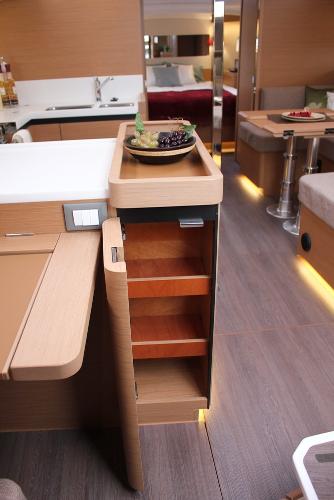 Slide: The Image of 2024 Jeanneau Sun Odyssey 440 interior with modern kitchen and wooden storage shelves. - 24