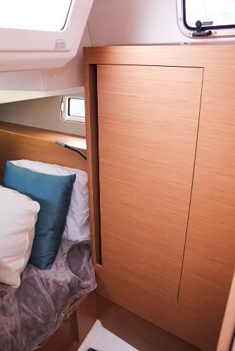 Slide: The Image of 2024 Jeanneau Sun Odyssey 440 cabin interior with wooden paneling and cozy bedding. - 32