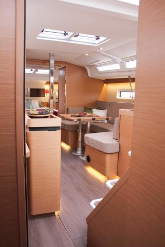 Slide: The Image of 2024 Jeanneau Sun Odyssey 440 interior with modern wood finish and cozy seating area. - 34